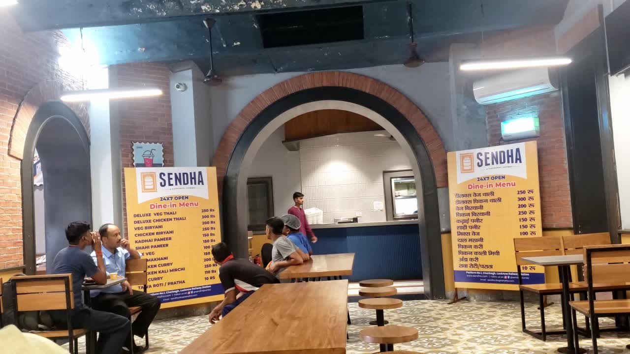 The video shows the interior of a restaurant where several people are seated at the tables, engaging in conversation with large menu boards displayed prominently - Restaurant concept
