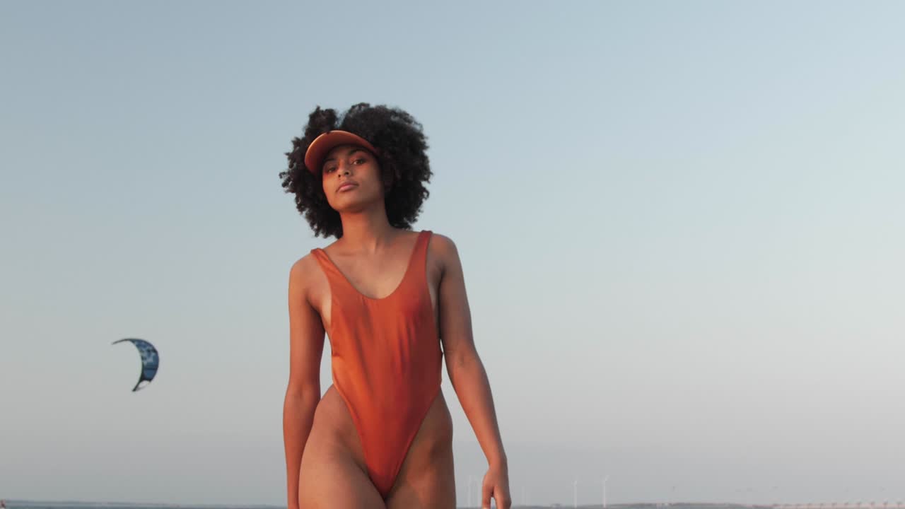 Mädchen mit lockigem Afrohaar geht auf die Kamera zu.