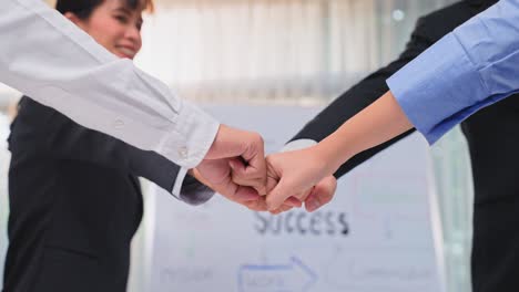 group of businessman and woman people fist bump together to motivate for corporate success in meeting conference room. colleagues employee team brainstorming and work as teamwork and unity in office.