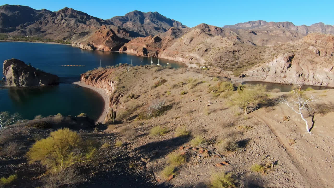 Fpv Drone Shot Over Coastal Arid Dry Hill Overlooking Sea Bay and Pleasure Boats On Water in Baja Region Mexico, Mountains in Horizon