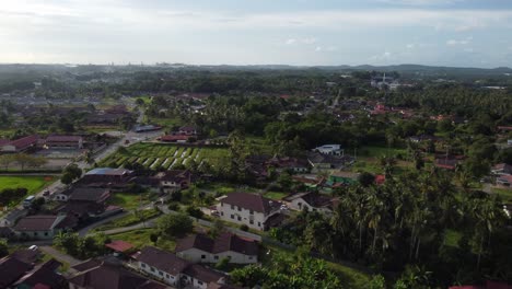una suave tarde soleada que muestra las casas de la aldea en melaka, malasia, con muchos árboles a mitad de la tarde