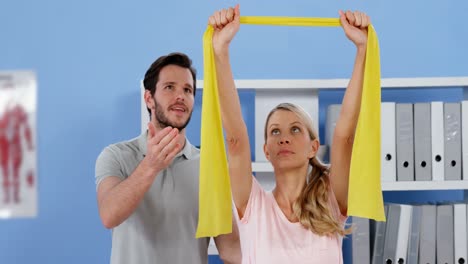 fisioterapeuta entrenando a una paciente con banda de ejercicio