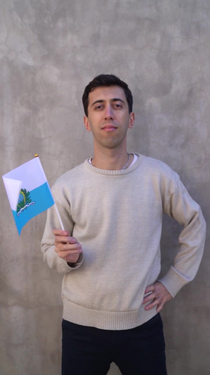Ripresa verticale di un uomo che sventola la bandiera sammarinese. Concetto di patriottismo. Rallentatore.
