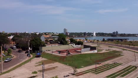 drone wide slow approach quite skate park with city and ocean in background