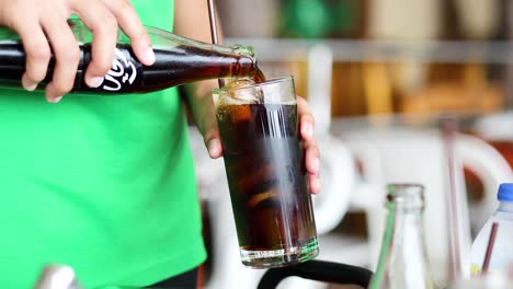 vertiendo refresco en un vaso