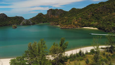 Luftaufnahmen-In-Zeitlupe,-Die-Ein-Ausflugsboot-In-Der-Nähe-Des-Strandes-Von-Tanjung-Rhu-In-Langkawi-Verfolgen