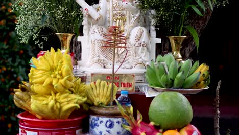 estatua rodeada de flores y frutas