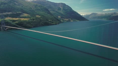 panning reveal drone shot of a suspension bridge on a sunny day