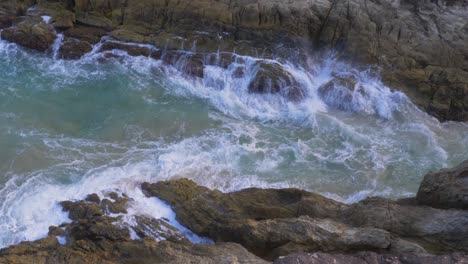 ocean waves crash into rocky valley of north gorge walk, point lookout, north stradbroke island, queensland australia