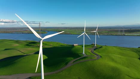 wind turbines producing energy on green hills near delta river in rio vista northern california