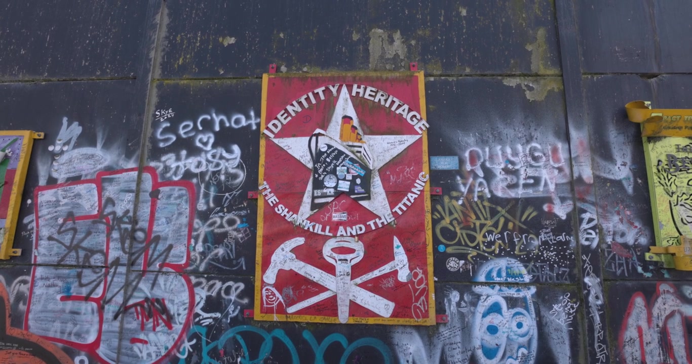 Olika konstverk och graffiti utställda på Fredsmuren i Belfast