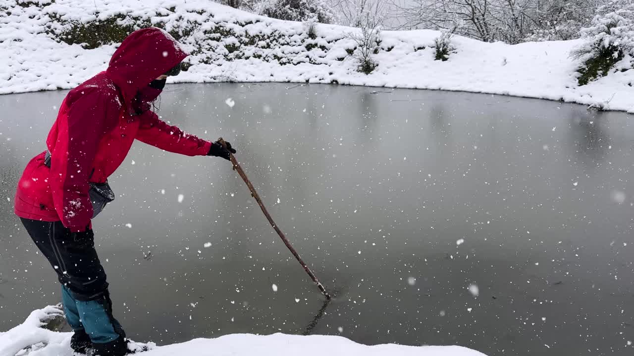 Frozen lake in forest panoramic view of heavy snowfall in winter cold season in Hyrcanian woman wear red jacket hiking adventure nature countryside mountain scenic landscape peaceful icy pond in Iran