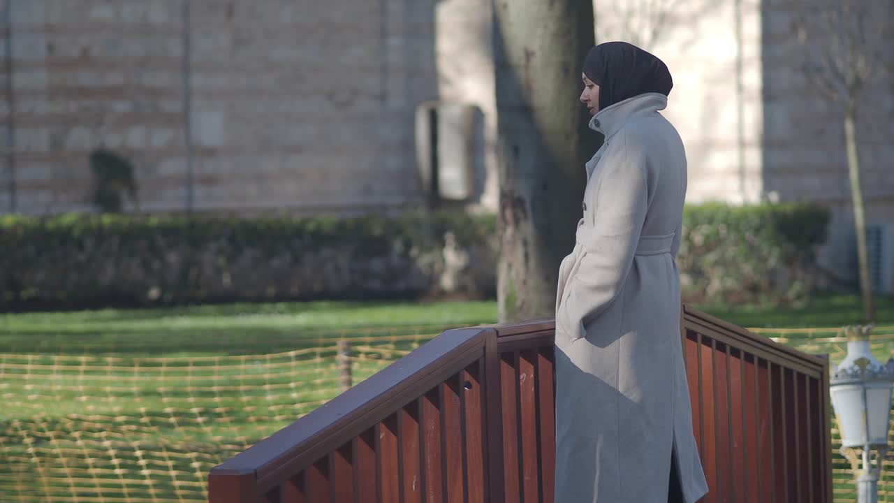 Woman in Hijab and Coat Standing and Walking in a Park