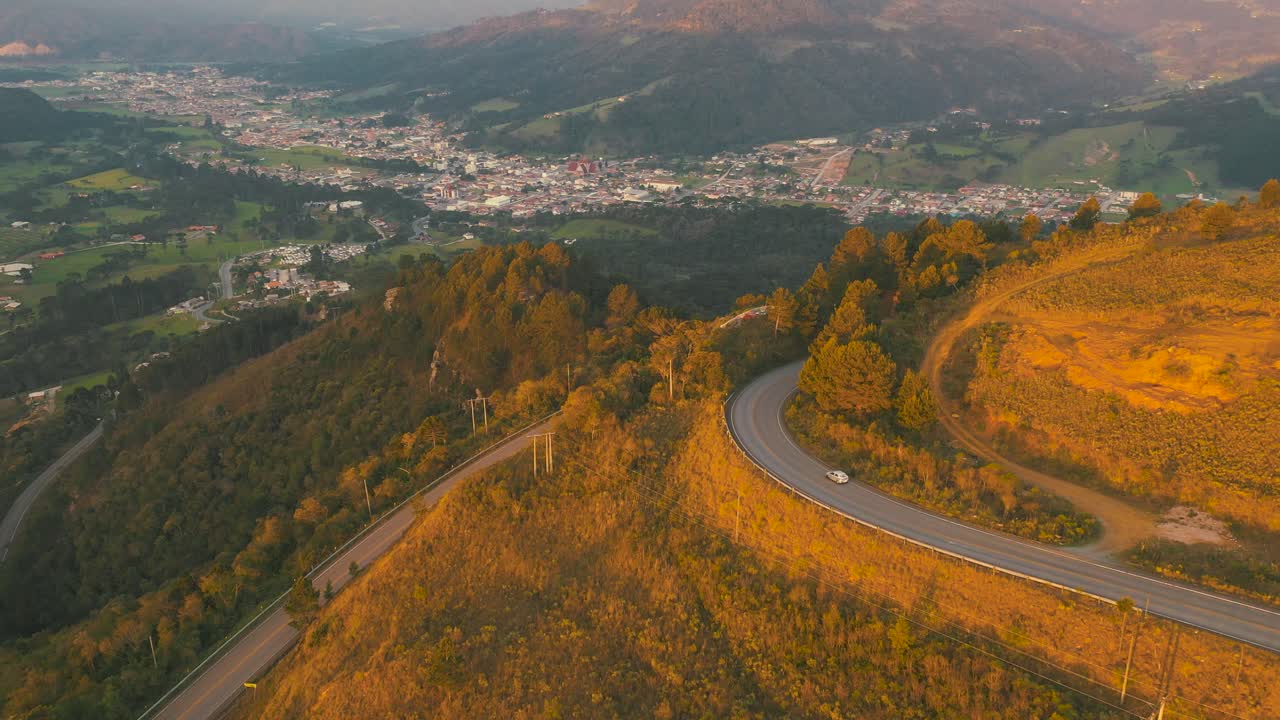 conducción de automóviles en una carretera de montaña al atardecer, que muestra la ciudad de urubici, ubicada en santa catarina, brasil