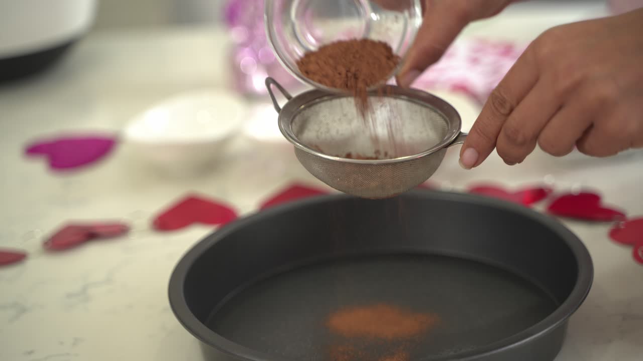 Nice shot of sifting chocolate cacao into a bowl of flour making a special valentine's day cake vegan chocolate cake eggless plant based dairy free