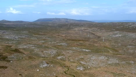 Vuelo-Aéreo-Sobre-La-Gran-Llanura-De-Sierra-En-Galicia-Con-Hileras-De-Aerogeneradores-En-El-Paisaje