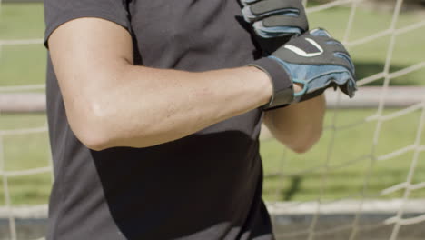 close up of a senior goalkeeper wearing gloves before match