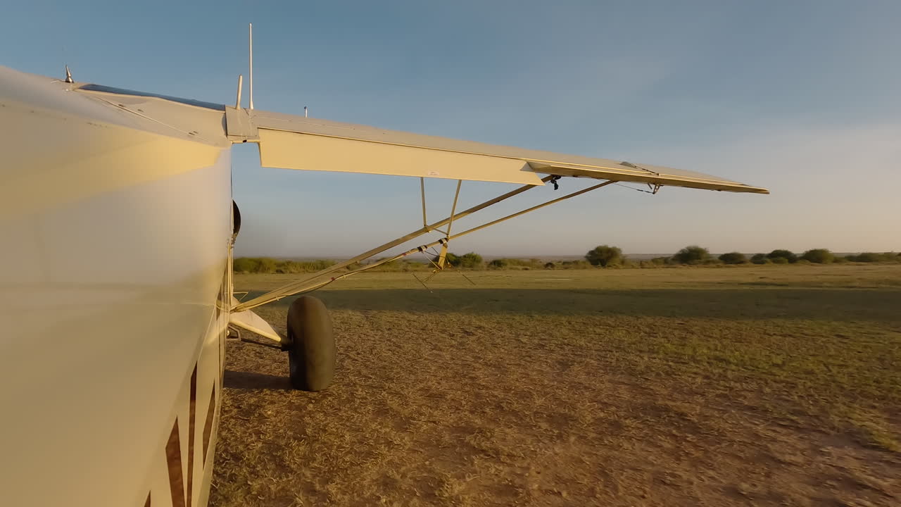 Kleines Flugzeug in Seitenansicht, Motor startet neben der Startbahn