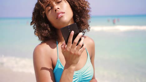 mujer riendo hablando por teléfono en la playa