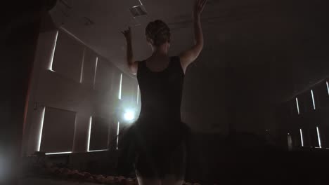 movimiento lento: ballet prima en el escenario ensayando la actuación en la luz oscura de la contra. las luces de la sala.