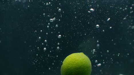 lime slice fruit splash falling down into white cocktail and water drinking glass shot in slow motion fun nutrition and drink concept