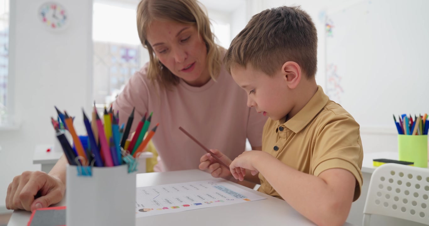Insegnante che aiuta un bambino con i compiti in classe
