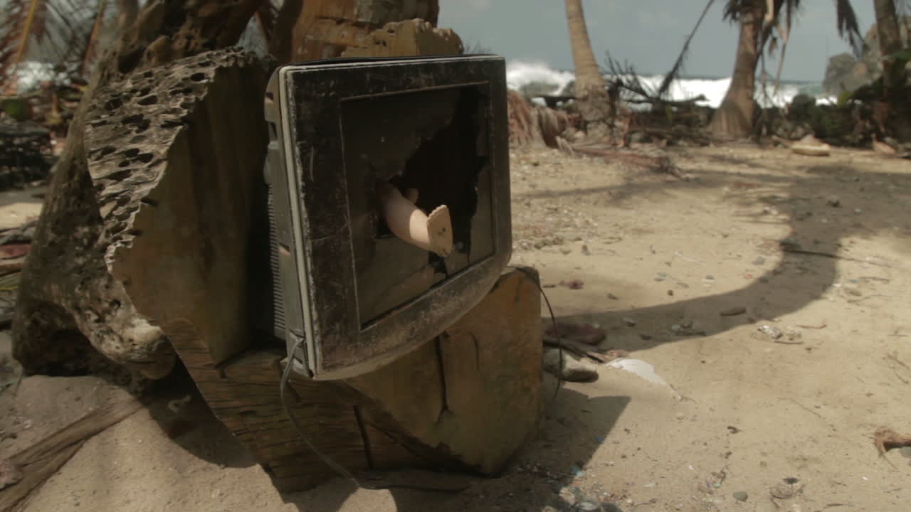 Broken tv with toy leg coming out, at a paradise beach by the Darien Gap in Colombia