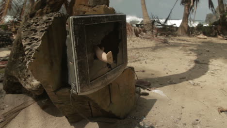 broken tv with toy leg coming out, at a paradise beach by the darien gap in colombia