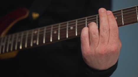 vista cercana del dedo de un guitarrista tocando una cuerda de guitarra, destacando la precisión y la técnica de la mano del músico. la toma detallada captura las complejidades de las cuerdas de la guitarra