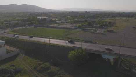 Aerial-tracking-shot-of-an-SUV-driving-over-a-railway-bridge