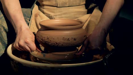 pottery worker removes a vase from a wheel, using a special line.