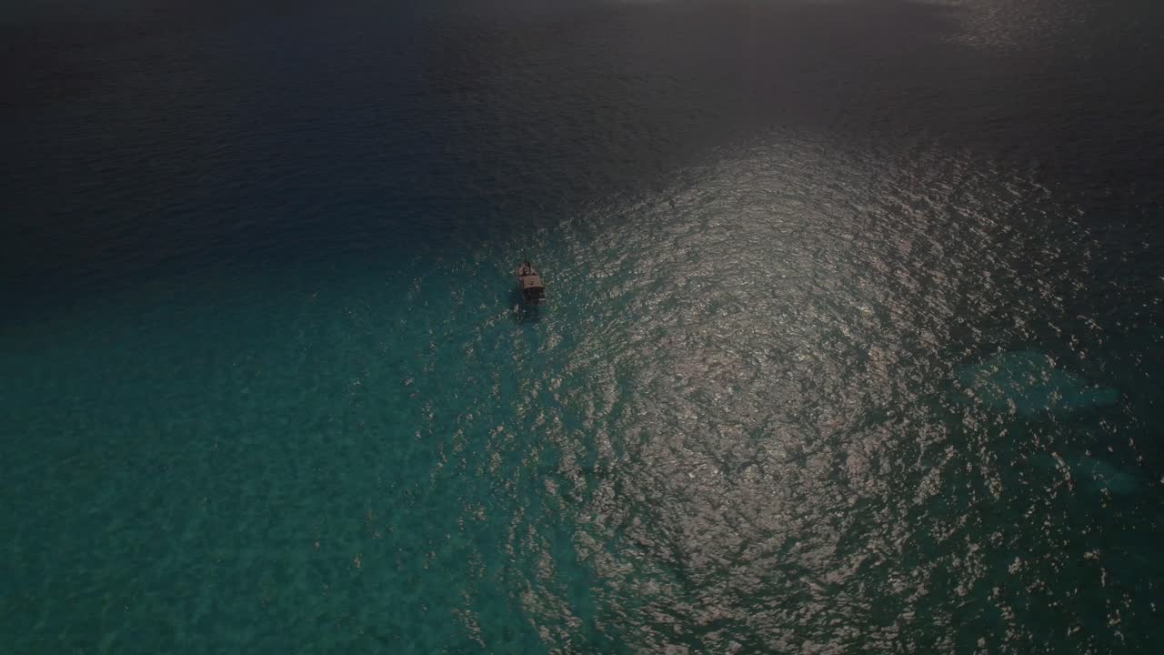 esta escena idílica captura la tranquilidad y la belleza de la riviera maya, mostrando un barco pacíficamente a la deriva en medio de las aguas turquesas y las costas prístinas de este destino celestial.