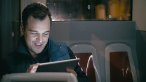 hombre sonriente en el autobús con una tableta