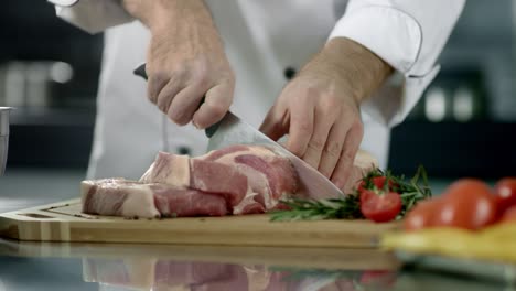 chef hands cutting pork fillet at kitchen. chef hands cutting fresh meat