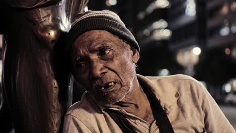 a thoughtful elderly man reflecting on life while resting in the city at night, capturing moments of solitude and contemplation amidst urban surroundings
