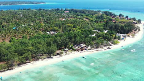 tranquil exotic beach of tropical island full of palm trees and bar restaurants, surrounded by shallow turquoise lagoon in gili meno,indonesia