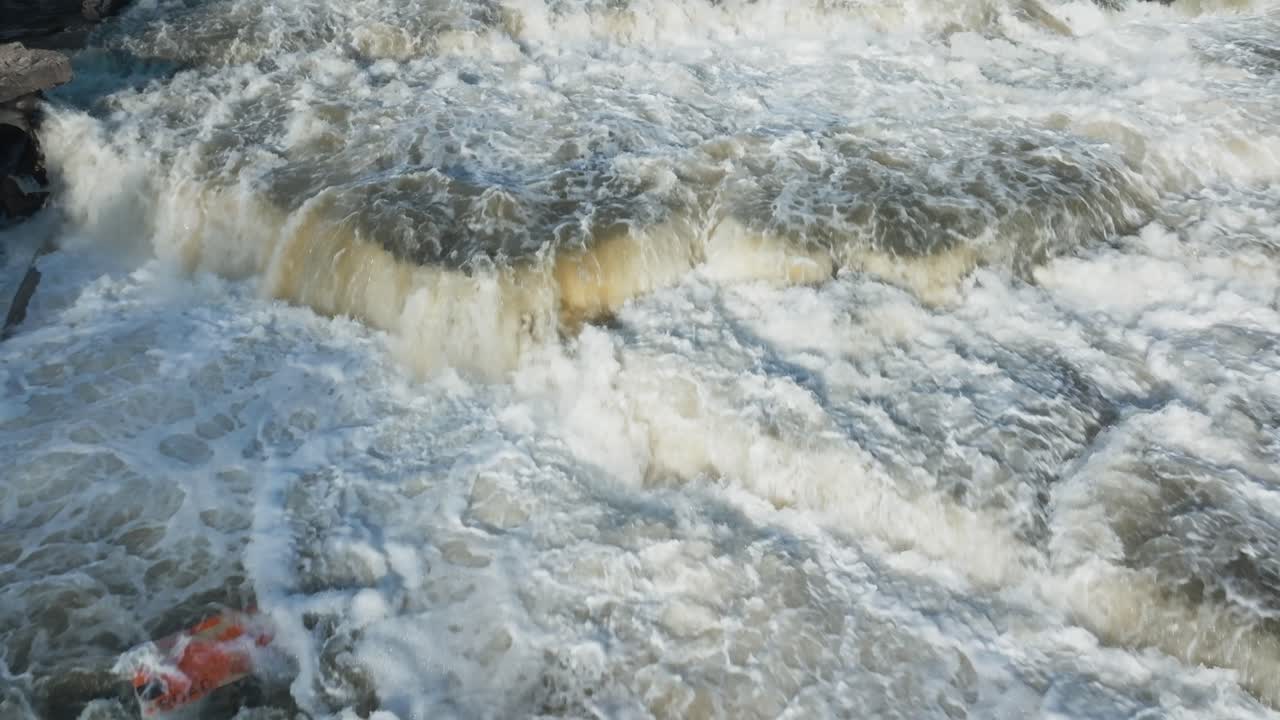 A powerful waterfall in Owen Sound, Canada, with turbulent water and misty spray