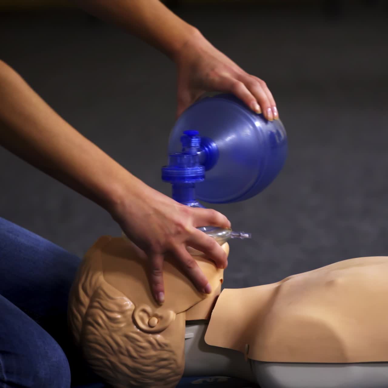 Teaching procedure on a dummy. Medical demonstration of resuscitation on a mannequin in training center. Instructor showing breathing exercise with medical apparatus