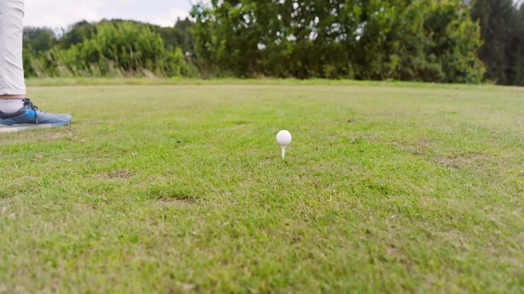 Golfista donna che gioca a golf e colpisce la pallina da golf su un campo da golf, con spazio per il testo.