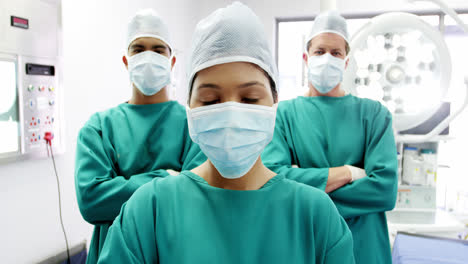 portrait of surgeons and nurse standing with arms crossed in operation room