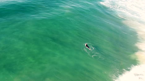 vista aérea de drones de olas rompiendo mientras el surfista está remando en la playa de arena romper la entrada océano pacífico nsw costa central australia 4k