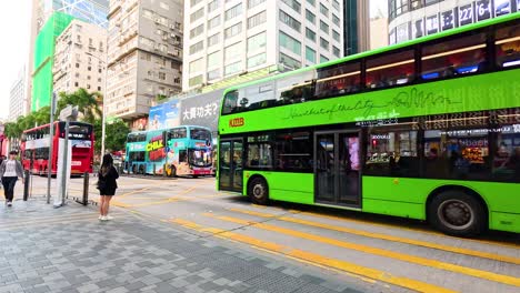 red and green buses on busy city street