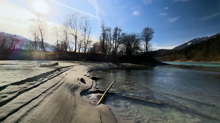 Rallentatore - Tracce di piena nella sabbia sul verde fiume Inn in Tirolo.