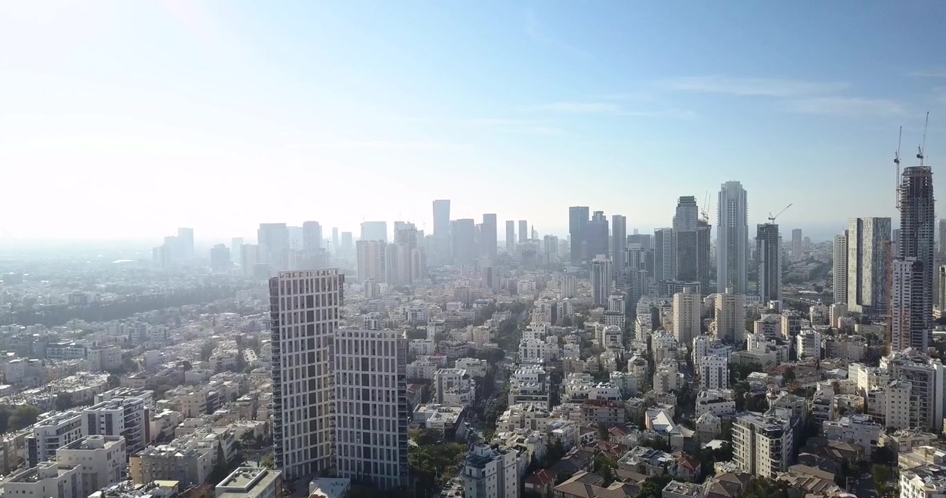 Voo cinematográfico de drone movendo-se em direção ao horizonte de Tel Aviv, Israel. Imagens aéreas apresentando desenvolvimento urbano denso, arranha-céus modernos, distritos comerciais, bairros residenciais e o rap.