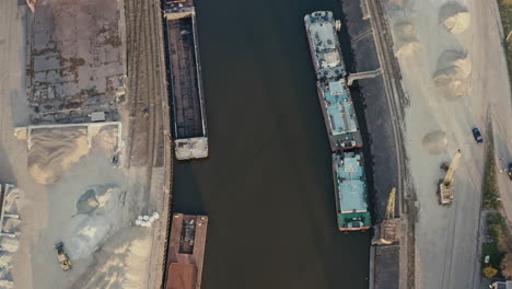 aerial view of a canal with barges and industrial facilities