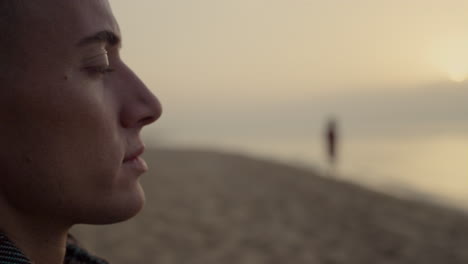 thoughtful man enjoying ocean landscape at sunset. dreamy guy blinking eyes