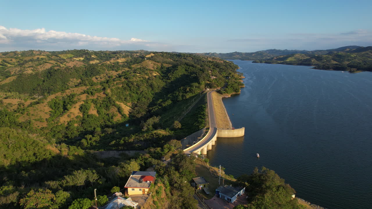fotografía aérea del puente de la presa y el lago artificial en la república dominicana a la hora de la puesta del sol, presa de tavera