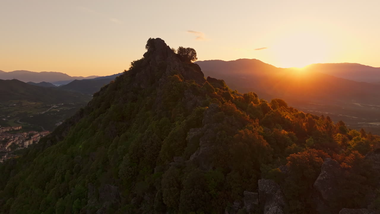 Early morning sunrise. Aerial drone shot over the stunning mountainous landscape in inland Corsica, France.Sun rising up from the mountains in the background. Golden hour