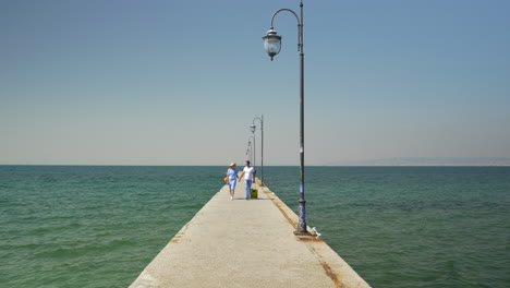 Young-couple-with-suitcase-on-the-pier