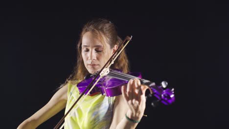 woman playing violin on black background.